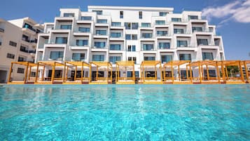 A modern hotel with a pool and outdoor seating.