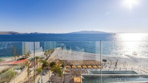 Een hotel aan de kust met uitzicht op zee, een zandstrand en een heldere lucht.