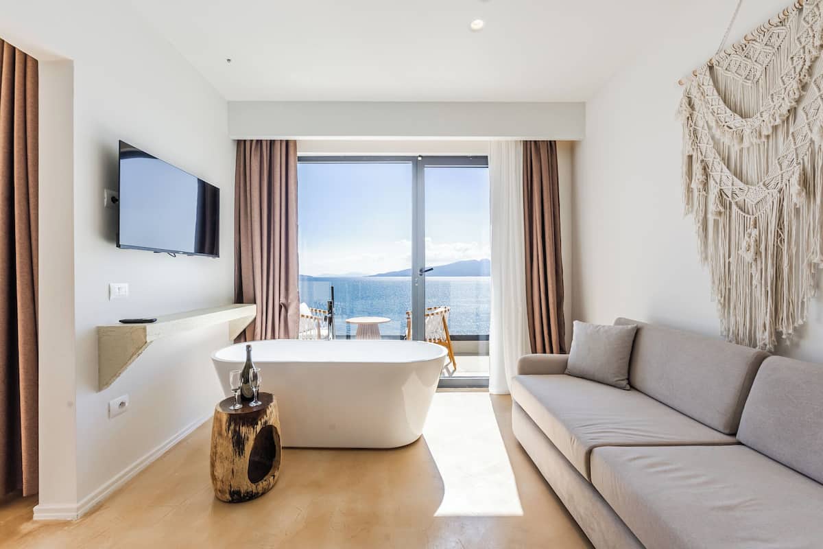Een moderne woonkamer met een groot raam, een flatscreen televisie, een bank en een bijzondere houten bijzettafel.