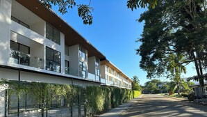 Un bâtiment moderne doté d’un toit plat, de grandes fenêtres et d’un chemin pavé qui le longe.