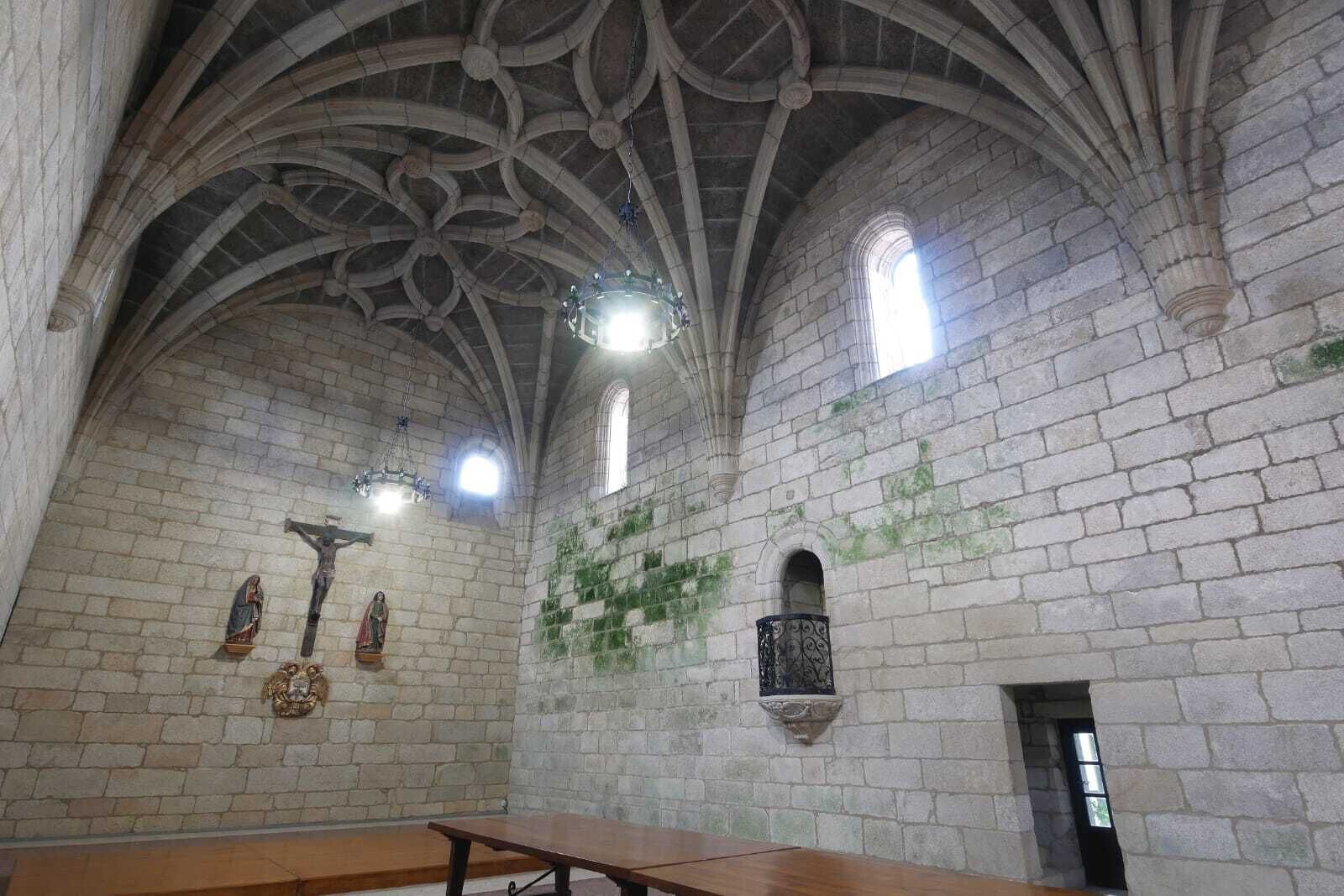 Ein Dominneres mit hohen Gewölbedecken, Steinwänden und einer hölzernen Kirchenbank.