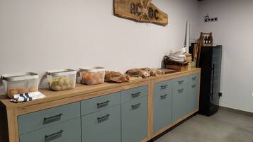 A kitchenette with a wooden countertop, a black refrigerator, and a wall-mounted wooden sign.