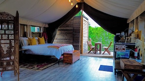 A cozy bedroom with a bed, wooden furniture, and a view of greenery outside. - Lost Horizon Texas (Kempner)