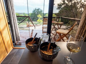 Et spiseområde med to skåle ramen og et glas hvidvin på et bord.