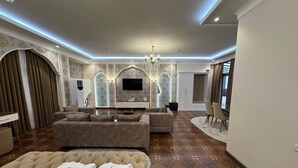 Un salon spacieux avec un grand canapé, un téléviseur à écran plat et une cheminée.