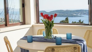 A round table with a vase of red tulips, blue candle holders, and a blue cloth. - Villa Judita Dubrovnik (Dubrovnik)