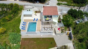 A modern two-story house with a swimming pool, a balcony with a table and chairs, and a garden area. - Villa Judita Dubrovnik (Dubrovnik)