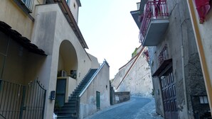 A narrow cobblestone street flanked by buildings with arched doorways and balconies. - La Brezza Home (Piano di Sorrento)