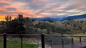 Une vue magnifique depuis un balcon donnant sur un paysage montagneux, au moment du coucher du soleil.