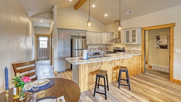 A spacious kitchen with a central island, wooden accents, and modern appliances.