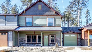A two-story house with a stone foundation, a front porch, and a garage.