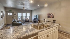 A kitchen with granite countertops, stainless steel appliances, and a dining area with a table and chairs.