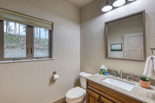 Un baño con inodoro, lavabo y ventana.