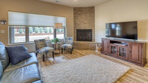 A living room with a fireplace, a television, a sofa, and a coffee table. - Mt Rushmore Retreat hosted by Rockerville Gold Town Lodging • 8 Min Drive | 2 Bedroom Sleeps 6- Fireplace (Rockerville)
