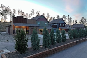 Uma casa moderna de vários andares com um jardim bem cuidado e uma entrada para carros.