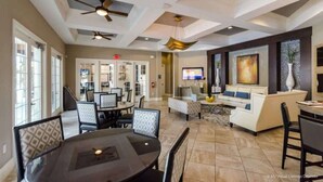 A spacious dining area with a round table and chairs, a living area with a sofa and TV, and a ceiling fan. - Newly Remodeled Disney Vacation Home (Davenport)