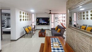 A modern living room with a TV, seating, and decorative wall art.