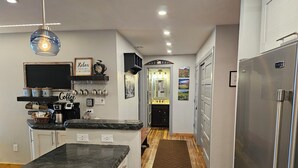 A modern kitchen with a marble countertop, stainless steel appliances, and a wooden floor. - Center of Downtown Breck, walk to slopes and Main Street! Steps to Riverwalk. (Breckenridge)