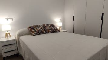 1 dormitorio y tabla de planchar con plancha