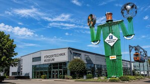 Un edificio con la inscripción 'Förderechnik Museum' y una gran escultura verde en su fachada.