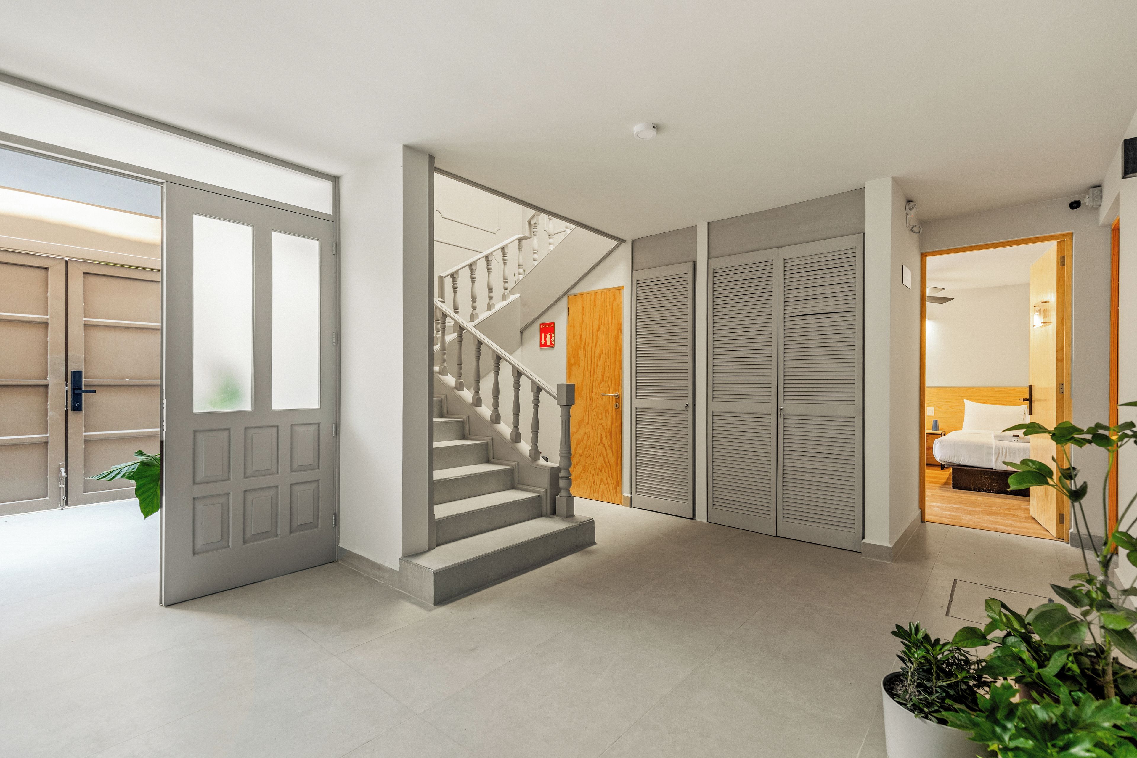 En modern inredning med en trappa, en säng och en växt.