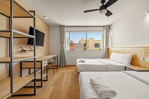 A hotel room with two beds, a desk, a TV, and a window with a city view. - Musgo by Homirent (Querétaro)
