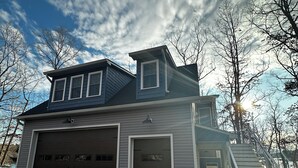 Ein zweistöckiges Haus mit Garage, einer Veranda und einer Treppe zum Eingang.