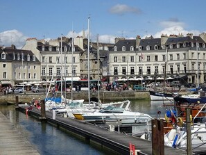 A marina with boats docked, a waterfront promenade, and historic buildings in the background. - T3 Lumineux Cœur de Ville Parking Voiture Sécurisé et Garage Vélos Inclus (Vannes)