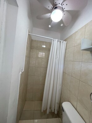 A small, enclosed shower area with a ceiling fan and a light fixture. - Rommar Cozy Suite (CAY HILL ,LITTLE BAY)