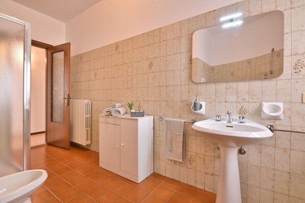 A bathroom with a white sink, a mirror, a towel rack, and a cabinet. - Casa Tullio by Theater Home - perfect for a big family (Gargnano)