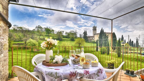 Ein Tisch im Freien mit Blick auf eine grüne Landschaft und ein Gebäude in der Ferne.