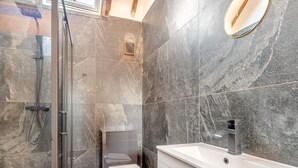 A modern bathroom with a glass-enclosed shower, a toilet, and a vanity with a sink. - Corley Rocks Barn - UK45939 (Corley)