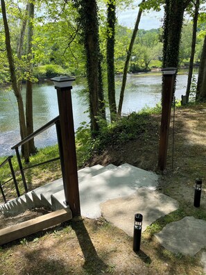 Stroll down to the river's edge along a winding staircase surrounded by lush greenery and trees.