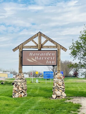 A wooden sign with the text "Hawarden Harvest Inn" supported by stone pillars. - Hawarden Harvest Inn (Hawarden)