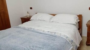 A bedroom with a bed, a nightstand, and a dresser. - 1 Bedroom Apartment in Procida (Procida)