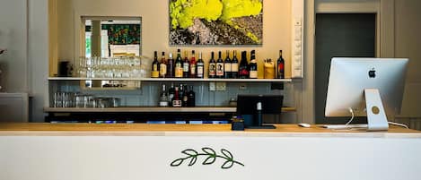 A bar area with a computer and various bottles of liquor.