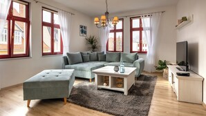 En moderne stue med en hjørnesofa, et lille bord og et TV-møbel.