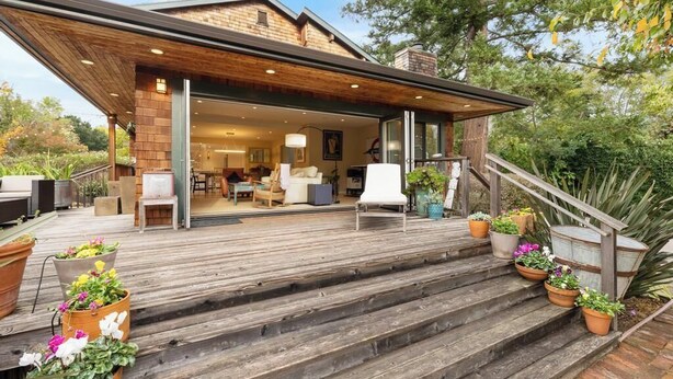 A modern house with a wooden deck, outdoor seating, and potted plants. - Stunning Marin County home with pool (San Anselmo)