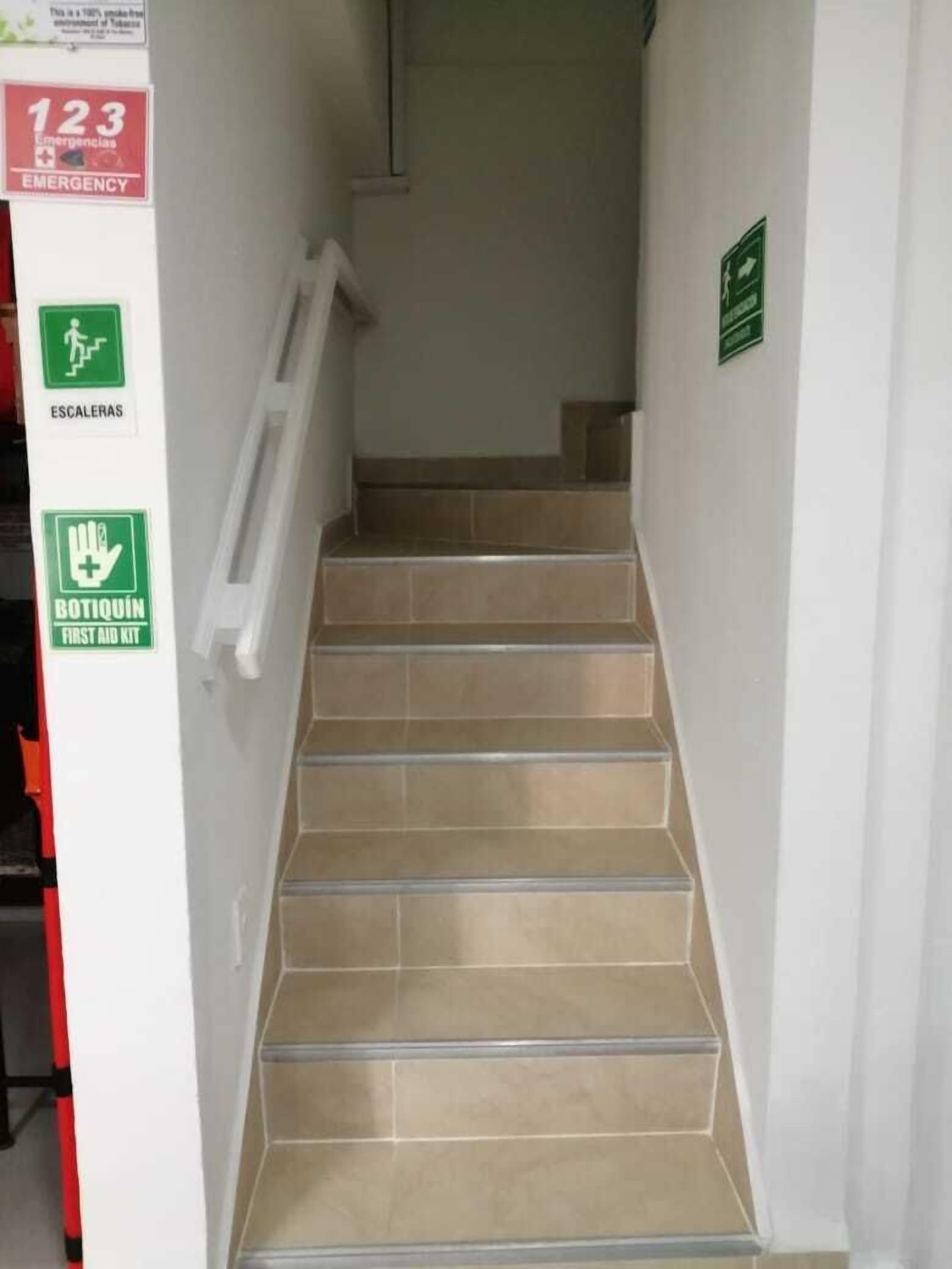 Eine Treppe mit Notbeschilderung und einem Erste-Hilfe-Kasten.
