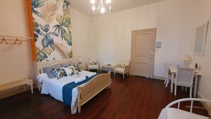 A bedroom with a bed, two chairs, a desk, a door, and a chandelier. - Domaine De l Ourbise  (Razimet)
