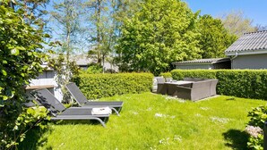 Ein Garten mit Terrasse, Grill und Pool.