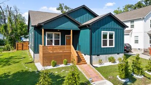 A two-story house with a front porch, a wooden deck, and a small garden with young trees. - Stylish Chattanooga Retreat Minutes to Downtown (Chattanooga)