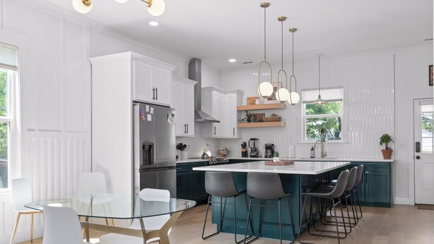 A modern kitchen with white cabinetry, a central island with bar stools, and pendant lighting. - Stylish Chattanooga Retreat Minutes to Downtown (Chattanooga)