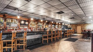 A bar area with wooden chairs and a marble counter.