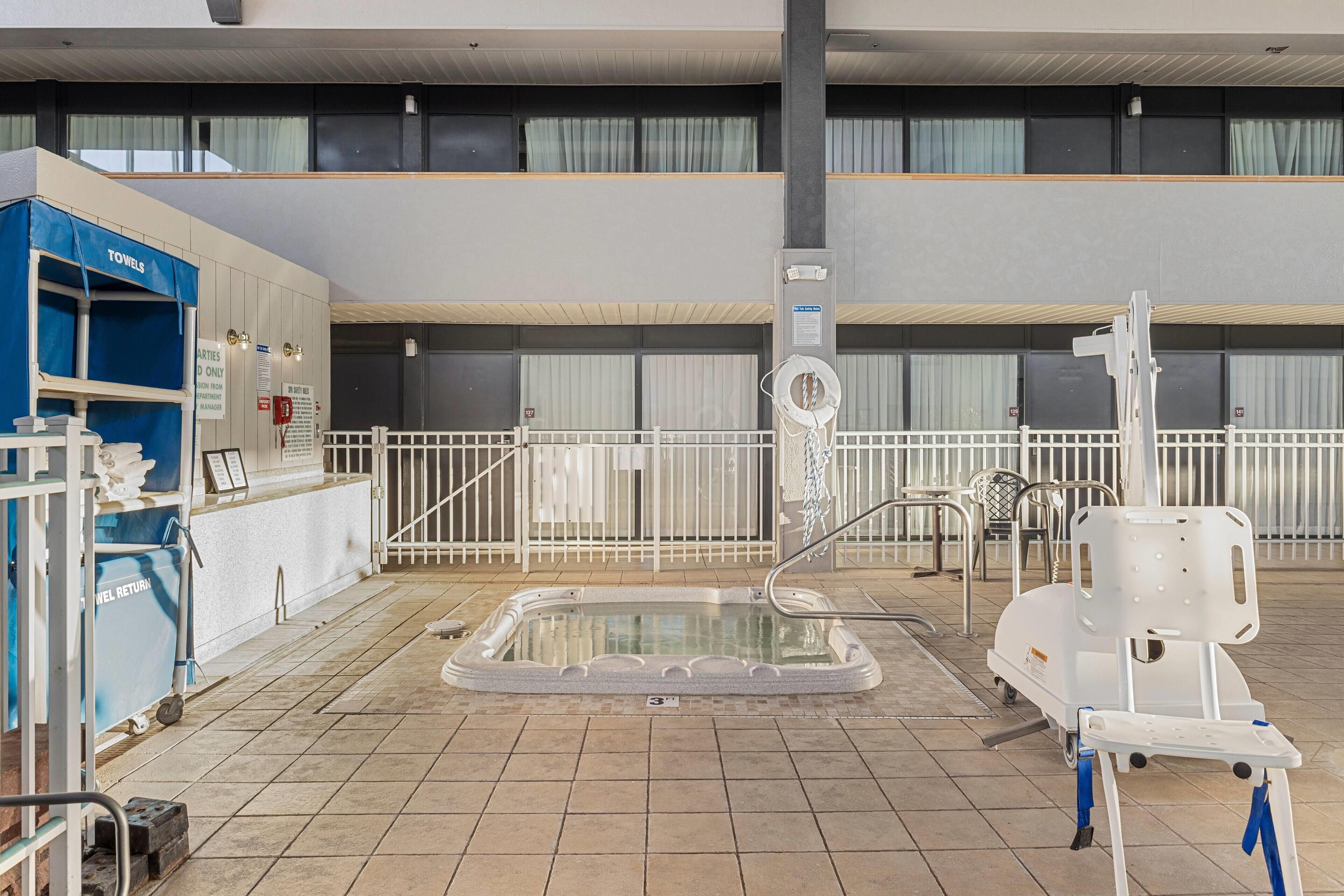 A pool area with a water slide, a towel station, and a wheelchair-accessible pool lift.