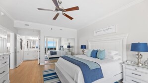 A spacious bedroom with a large bed, a ceiling fan, and a view of the ocean. - Salty Breezes (Navarre)
