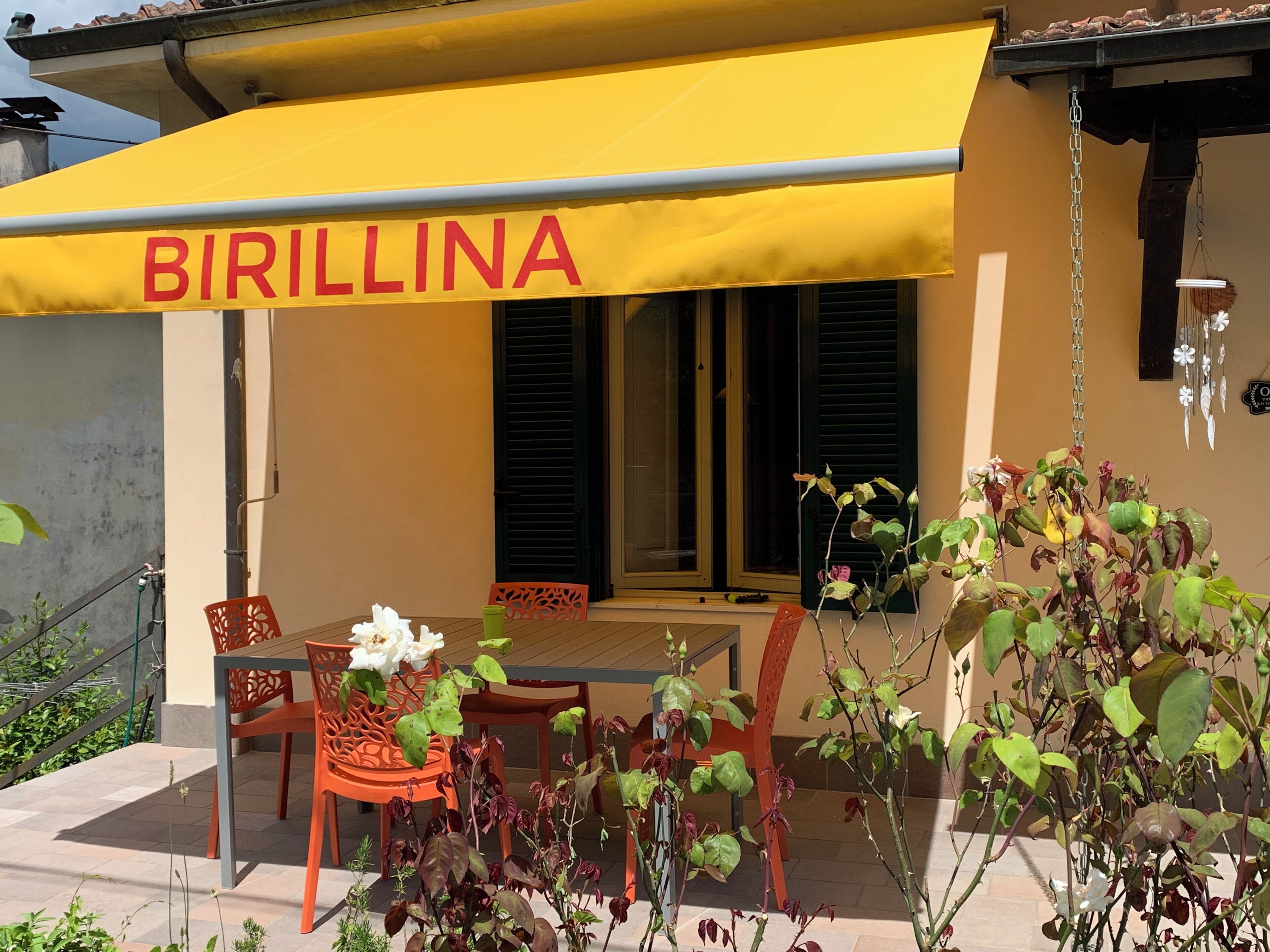 A restaurant named 'BIRILLINA' with outdoor seating and a yellow awning.