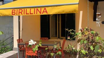 Un ristorante chiamato 'BIRILLINA' con posti a sedere all'aperto e un tendone giallo.
