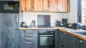 Une cuisine moderne dotée de meubles en bois, d’un four à micro-ondes, d’un grille-pain et d’une machine à café.