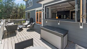 A deck with outdoor furniture, a sliding glass door, and a view of the interior. - Glebe Getaway House (Arlington)